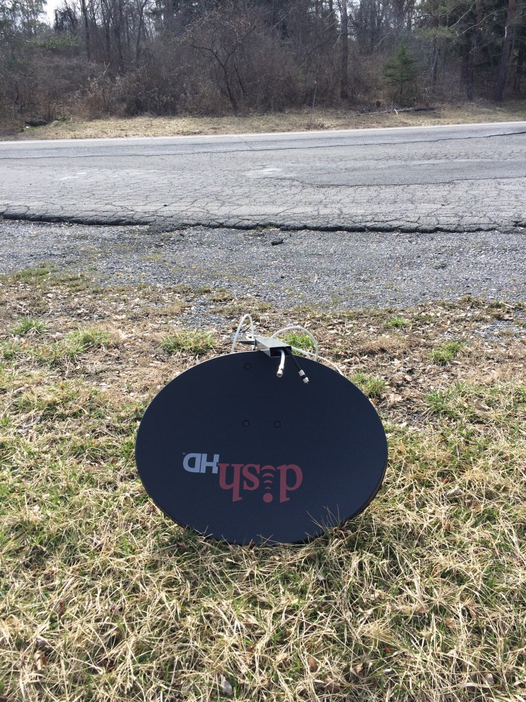 A satellite dish lies in the grass at a popular pull off area, miles north of Taughannock Falls State Park